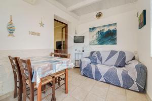 a dining room with a table and a couch at Casa Athena - Goelba in Portoferraio