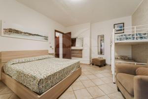 a bedroom with two bunk beds and a couch at Casa Athena - Goelba in Portoferraio