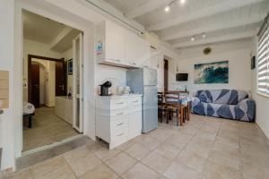 a kitchen and living room with a couch and a table at Casa Athena - Goelba in Portoferraio +15 photos
