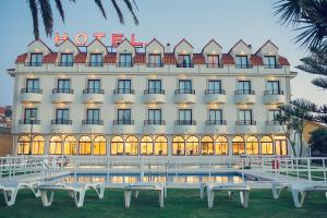 a hotel with white benches in front of it at Hotel Restaurante Glasgow in Villadesuso