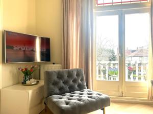 a living room with a chair and a large window at Lovely Spacious Apartment in Zandvoort
