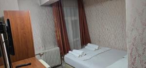 a small room with a bed and a mirror at HOTEL Kenan in Doğubayazıt