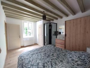 a bedroom with a large bed and a kitchen at La petite maison de Sandra in Le Plessis-Grohan