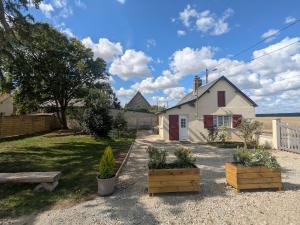 a house with two potted plants in a yard at La petite maison de Sandra in Le Plessis-Grohan