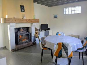 a dining room with a table and a fireplace at La petite maison de Sandra in Le Plessis-Grohan