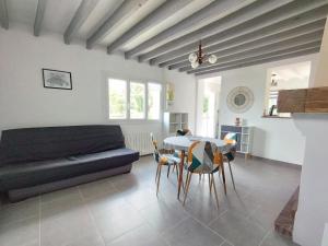 a living room with a couch and a table and chairs at La petite maison de Sandra in Le Plessis-Grohan +27 photos