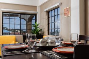 a dining room with a table with plates and glasses at Ahra Suites First Floor with ocean view in Kingstown