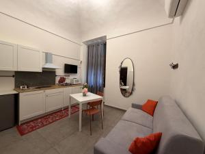 a living room with a couch and a table and a kitchen at A ca' de Lisetta in Albenga