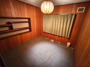 an empty room with a window and a lamp at オホーツクハウスえんがる in Engaru