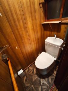 a small bathroom with a toilet and wooden walls at オホーツクハウスえんがる in Engaru +5 photos