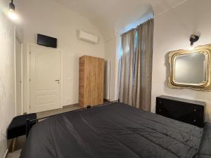a bedroom with a bed and a mirror and a tv at A ca' de Lisetta in Albenga