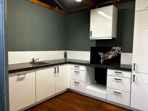 a kitchen with white cabinets and a sink at Bell Tent in Elim +49 photos