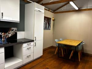 a kitchen with a table and a refrigerator and a table and chairs at Bell Tent in Elim