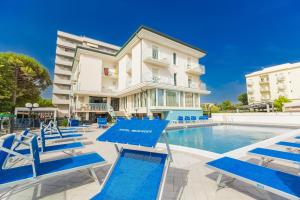 a villa with a swimming pool and blue lounge chairs at Hotel Mercedes in Misano Adriatico