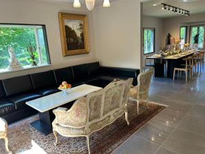 a living room with a couch and a table and chairs at Izu Plateau House 420 square meters, BBQ , 8 bedrooms, 1 living room 1kitchen 6 toilets 4 bathroom 1 onsen in Yawatano