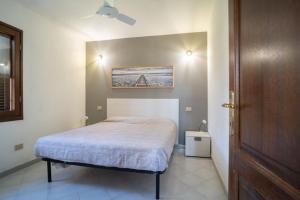 a bedroom with a bed and a painting on the wall at La Cinta Apartments in San Teodoro
