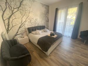 a bedroom with a bed and a chair at Lilly Garden Lago Lugano with private parking garden and air conditioning in Porlezza