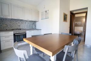a kitchen with a wooden table and chairs at La Cinta Apartments in San Teodoro