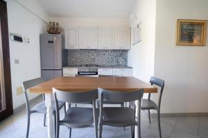 a kitchen with a wooden table and chairs at La Cinta Apartments in San Teodoro