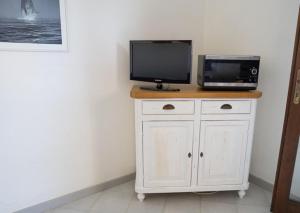 a tv sitting on top of a cabinet with a microwave at La Cinta Apartments in San Teodoro +33 photos