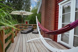 a hammock and an umbrella on a deck at Ferienhaus Sjö Hus Pülsen - Köhn in KÃ¶hn +17 photos