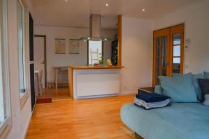 a living room with a blue couch and a kitchen at Ferienhaus Sjö Hus Pülsen - Köhn in KÃ¶hn