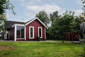 a small red house with a yard at Ferienhaus Sjö Hus Pülsen - Köhn in KÃ¶hn
