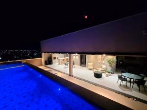 a house with a swimming pool at night at Studio moderno, rooftop com piscina, próx UFU in Uberlândia