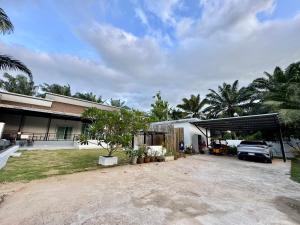 a house with a car parked in the driveway at บ้าน อินอักษร in Pumriang