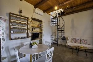 a living room with a table and chairs and a fireplace at Manoli's Light Stone House in Vathi