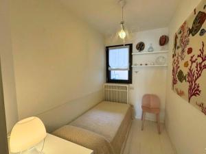 a small room with a bed and a window at Appartamento Tilatti in Grado