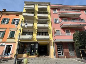 a yellow building in front of a building at Appartamento Tilatti in Grado