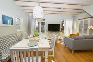 a living room with a table and chairs and a living room at Residenz R1 App 1 in Behrensdorf