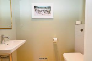 a bathroom with a sink and a toilet and a picture at Residenz R1 App 1 in Behrensdorf +30 photos