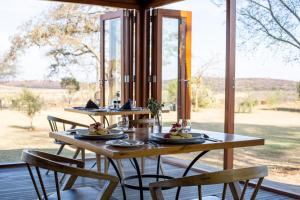 a wooden table with plates of food on it at Cheetah Ridge Lodge in Nambiti Game Reserve
