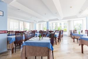 a restaurant with blue tables and chairs and windows at Hotel Mercedes in Misano Adriatico