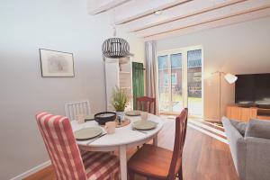 a dining room with a white table and chairs at Residenz R1 App 2 in Behrensdorf
