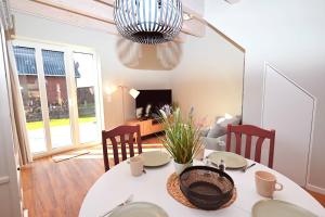 a dining room with a table and chairs and a chandelier at Residenz R1 App 2 in Behrensdorf