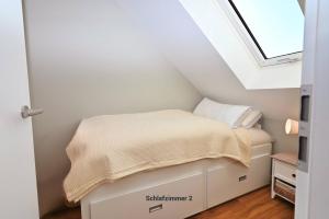 a small bed in a room with a skylight at Residenz R1 App 2 in Behrensdorf