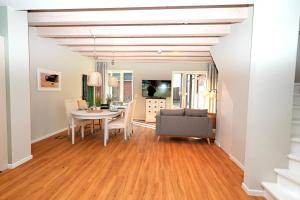 a dining room and living room with a table and chairs at Residenz R1 App 3 in Behrensdorf