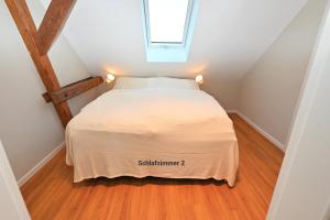 a small bedroom with a bed in a attic at Residenz R1 App 3 in Behrensdorf