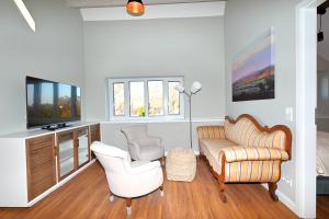 a living room with a couch and chairs and a tv at Residenz R1 App 4 in Behrensdorf