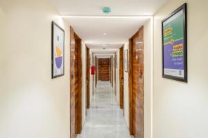 a corridor in a building with two pictures on the walls at Treebo Gateway Mansion in Mumbai