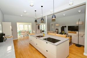 a kitchen with white cabinets and a living room at Residenz R1 App 5 in Behrensdorf