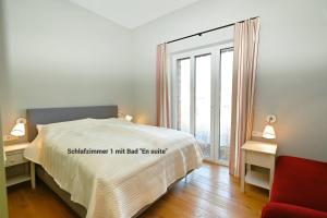 a bedroom with a bed and a large window at Residenz R1 App 5 in Behrensdorf