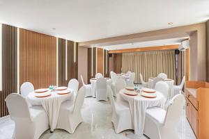 a conference room with white tables and white chairs at Treebo Gateway Mansion in Mumbai +45 photos
