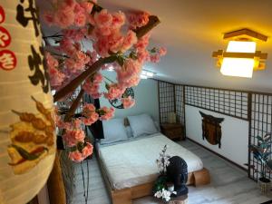 a bedroom with a bed and flowers in a room at Les Chambres de Paulette - LOGEMENTS A THEMES - CHAMBRE JACK SPARROW - CHAMBRE KOH LANTA - CHAMBRE HARRY POTTER - CHAMBRE ZEN in Sainte-Marie-la-Mer