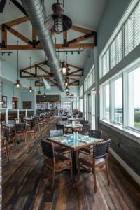 uma sala de jantar com mesas, cadeiras e janelas em Harborside at Charleston Harbor Resort and Marina em Charleston