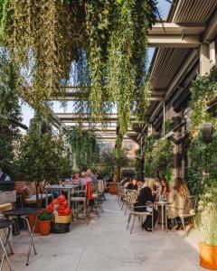 people sitting at tables in a restaurant with plants at Dakota Manchester in Manchester