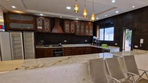 a kitchen with wooden cabinets and a marble counter top at Prestige Villa in Marrakesh